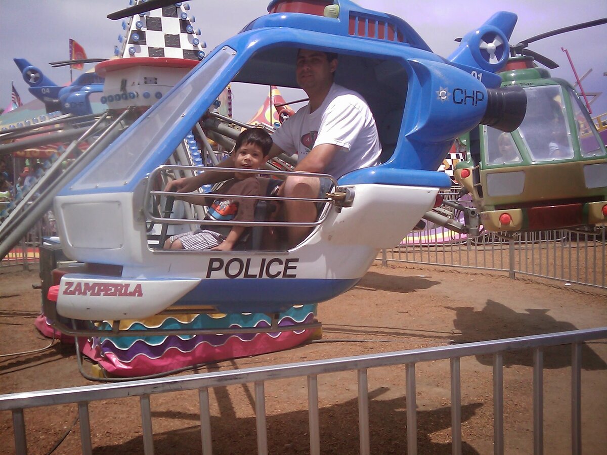 Young Jaden and dad on helicopter ride at amusement park